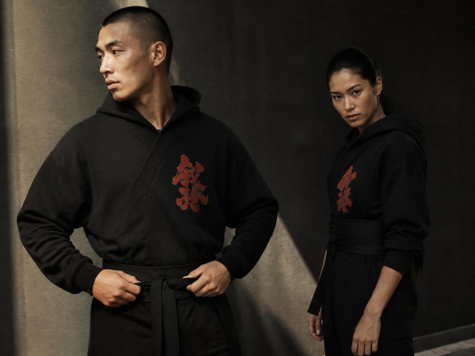 Two models in oversized Dogi hoodies with dojo-inspired graphics